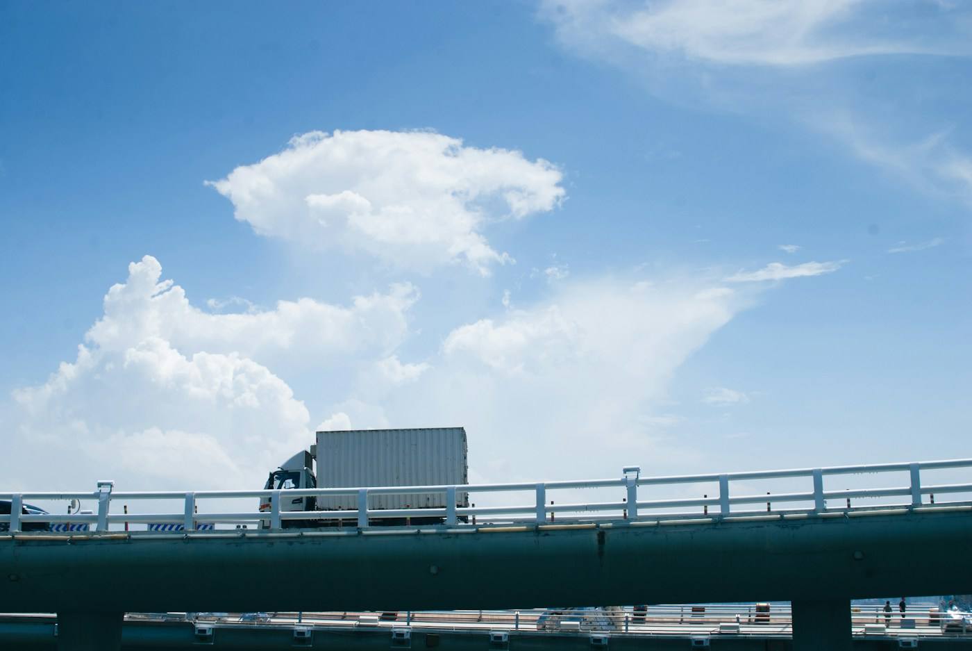 Caminhão baú leve atravessando uma ponte